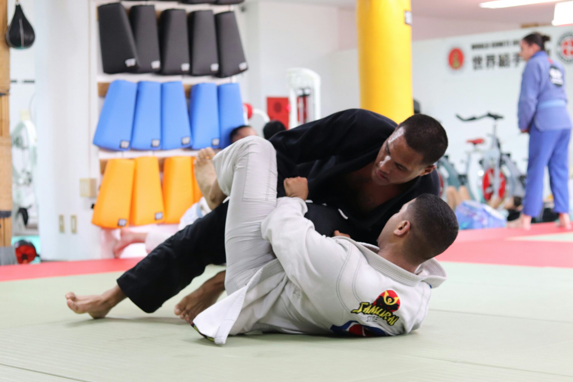 A man demonstrates a Brazilian Jiu-Jitsu maneuver, depicted in a dramatic black and white style